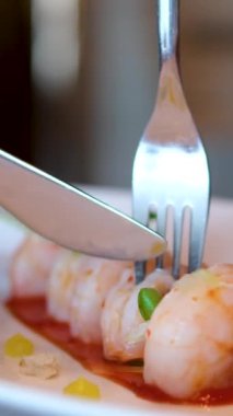 Patlamış karides yaban turpu, meyer limon, baharatlı kokteyl sosu. Bıçak ve çatalla kesilmiş.