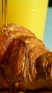 Kruvasanın üzerine bal dök. Pişirme akçaağaç şurubu dikey video ile yapılır. ayçöreği üzerine akçaağaç şurubu serpiştir