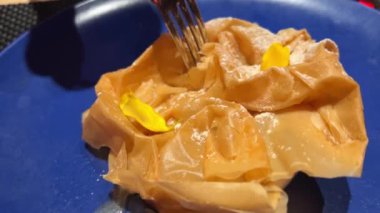 Krema soslu armutlu pudra şekerli pasta mavi bir tabakta servis ediliyor. Yüksek kalite 4k görüntü