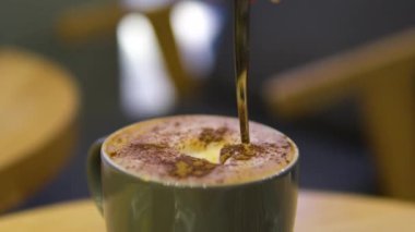 Tarçınlı kahve. Kahve bardağına tarçın tozu serpin. Kahve ve tarçın karışımı.