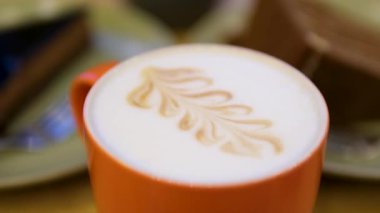 Latte sanatıyla kahve bardağının en üst görüntüsü. Kalp şeklinde sıcak Latte sanat kahvesi. Sıcak kahveyle dolu bir fincanda beyaz kalp şeklinde latte sanat eseri. Yüksek kalite 4k görüntü