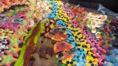 Şekercideki tahta kutularda bir sürü renkli meyve şekeri yatıyor. Çocuklar için lezzetli ve güzel, parlak hediyeler. Yüksek kalite 4k görüntü