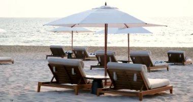 Güzel sahil. Deniz kenarındaki sahilde sandalyeler. Yaz tatili ve turizm için tatil konsepti. İlham verici tropikal bir manzara. Sahilde şemsiyeli güneşlikler.