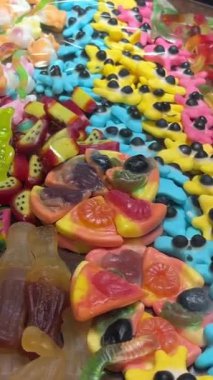 Şekercideki tahta kutularda bir sürü renkli meyve şekeri yatıyor. Çocuklar için lezzetli ve güzel, parlak hediyeler. Yüksek kalite 4k görüntü