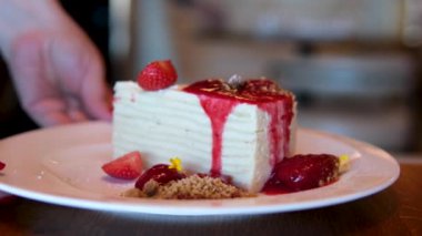 Profesyonel bir mutfakta silikon spatulayla çilek reçeli karıştıran bir kadın şefin yakın çekimi. Çilek reçelli beyaz pasta