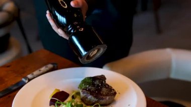 Biber soslu patates kızartması ve biftek. Beyaz tabak salata, et ve patates.