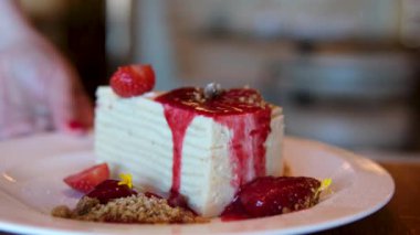 Ev yapımı çilekli kurabiye fincanı, taze çilek ve yakın çekimde krema yemek. Çilekli beyaz pasta kaşıkla yenir.