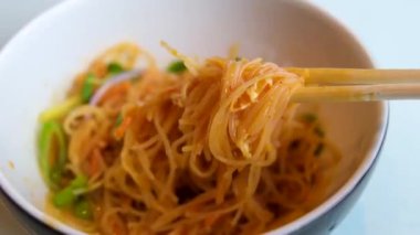 Kızarmış eriştenin yemek çubuklarıyla karıştırıldığı bir video. Kore eriştesi çubukları.