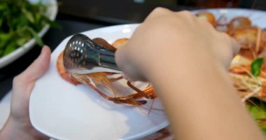 Kruvazör 'de büyük bir balık yemeğinin servis edildiği deniz ürünleri büfesi sahnesi. Balık sebze ve sosla süslenir, bir aşındırma kabına yerleştirilir. Bir insan balığı tabakta servis etmek için maşa kullanıyor.