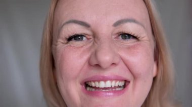 Gülümseyen, beyaz, genç bir kadın, elini kalp göğsüne koydu, evinde derin bir şükran duyuyor. Happy, minnet gösteren, minnettarlığını ifade eden güzel bir milenyum kadınına ilham verdi..