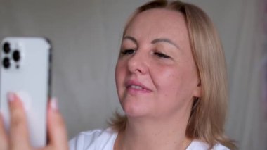 Okuma gözlüklü akıllı telefonuna bakan bir kadın. Yüksek kalite 4k görüntü