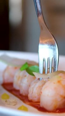 Yeşil ve limonlu beyaz tabakta karides. Ahşap arka plan, yakın plan. Yüksek kalite 4k görüntü