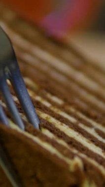 Çikolatalı pasta yiyorum. Çatalla lezzetli çikolatalı pastadan bir ısırık almak. Çikolatalı krema çatalla yenir.