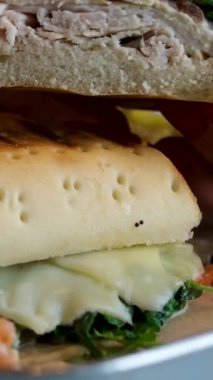 Masada füme tavuklu salamlı sandviç var. Peynirli sandviç ve tavuklu domatesli ıspanaklı cips. 