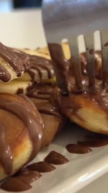 Erimiş çikolata, meyveli taze krep yığınının üzerine dökülür. Çikolatalı gözleme.