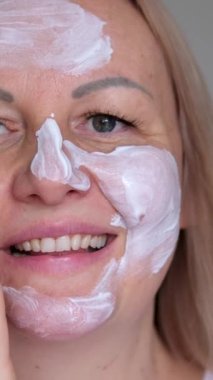 Mutlu kadın krem sürerken gülümser kahkahalar atarken pek çok krem beyaz yüz uygulanır ekonomik olarak değil. Yüksek kalite 4k görüntü