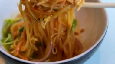 Pirinç vermicelli Papaya salatalı salata, pirinç vermicelli ve mayalanmış balık soslu tarifli kadın sokak yemeği yemeden önce kaşık ve çubuklarla erişteleri lezzetlerle karıştırır. Yüksek kalite 4k görüntü