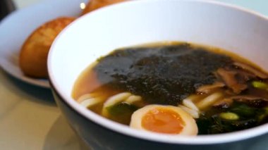 Lezzetli bir kase ramen, içinde mısır, yosun, erişte, yumurta ve et var. Yakın çekim zengin, besleyici çorbayı yakalar, yemek tutkunları için mükemmel bir aşçılık ilham kaynağıdır. Yüksek kalite