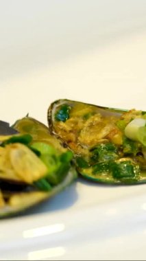 Deniz mahsullerine limon sıkmak. Tabağa limon suyu sıkıyorum. Tanınmayan erkek elleri kabuklu midyeleri otlar, limon ve soğanla hazırlıyor. Yüksek kaliteli FullHD görüntüler