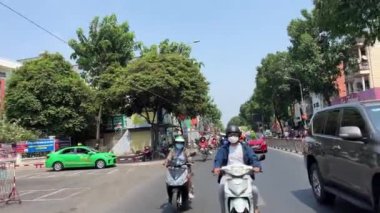 Motosikletçiler iş için çiçek almaya gider. Yerel halk çiçek satın alır. Ay 'ın yeni yılında Ho Chi Minh City, Vietnam' da 11.2024