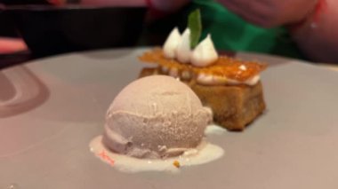 El çatalı bıçağıyla tatlı tatlı yiyorum. Yanında da krema kremalı karamel şurubu. Yüksek kalite 4k görüntü