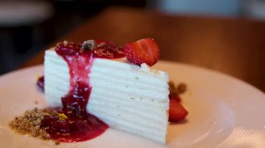 Bir dilim lezzetli süzme peynirli kek, çilekli, mavi tabağa çikolata dökülmüş. Lezzetli atıştırmalıklar, yakın yemek ve içki geçmişi. Yüksek kalite 4k görüntü