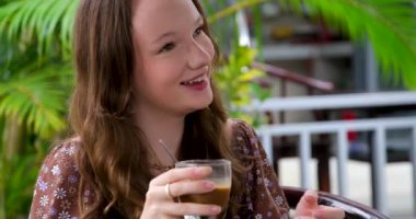 Kız gülüyor, arkadaşlarıyla iyi vakit geçiriyor, soğuk kahve içiyor. Yüksek kaliteli FullHD görüntüler