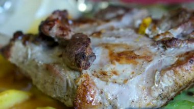 Şef taze ızgara et dilimliyor. Mutfaktaki ahşap kesme tahtasının üzerinde bıçakla. Yemekler yakınlaştırılıyor. Yüksek kalite 4k görüntü