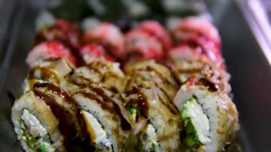 Renkli bir suşi tabağında çeşitli Rolls and Toppings 'li Soya Sosu. Yüksek kalite 4k görüntü