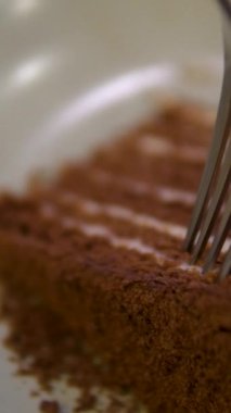 Bir kadın bir parça pastayı çatalla kırıyor. Yüksek kalite 4k görüntü