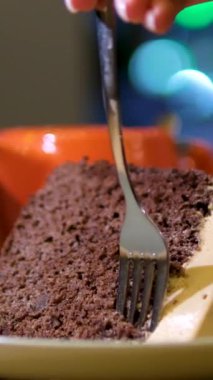 Lezzetli bir parça çikolatalı pasta yiyorum. Çikolatalı pasta yiyorum. Çatalla lezzetli çikolatalı pastadan bir ısırık alıyorum. Yüksek kalite 4k görüntü