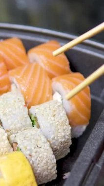 Japon yemeği somon balığı avokado maki suşi çubuğu yiyor. Yüksek kalite 4k görüntü