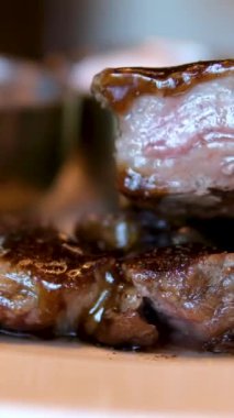 Mutfak bıçağı ve barbekü çatalı kullanarak biftek dilimine aşırı yakın çekim. Mükemmel pişirilmiş et dilimleme, yavaş çekim. Orta pişmiş biftek.