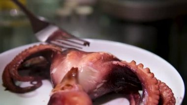 Sebzelerle servis edilen ahtapot, deniz ürünleri. Kaynamış ahtapot dokunaçları koyu taş bir tabakta, Asya, Akdeniz mutfağı, akşam yemeği. Üst Manzara. Siyah arka planda restoran menüsü. 4k 
