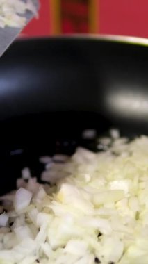 Tavada sıcak pişirme yağında kızartılmış soğan. Dikey video. Yakın plan. Yüksek kalite 4k görüntü