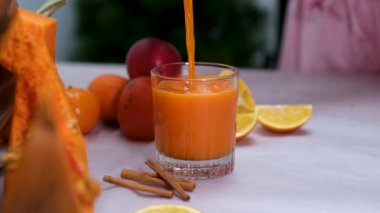 Balkabağı kabağı yanında balkabağı içeceği, bambu yüzeyinde dağınık meyveler, canlı sonbahar hasat teması zengin organik dokular, parlak renkler ve doğal ışık.