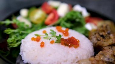 Kırmızı havyar salatalı pilav, Asya mutfağı, siyah tabak servis edilen bir restoranda. Yüksek kalite 4k görüntü