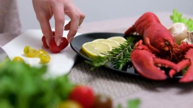 Istakoz tabağını dekore etmek için Beyaz Tahtada Keskin Bıçakla Domates Kesen Kişi. Yüksek kalite 4k görüntü