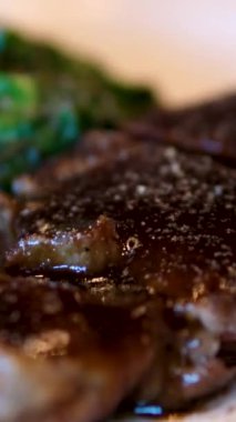 Mutfak bıçağı ve barbekü çatalı kullanarak biftek dilimine aşırı yakın çekim. Mükemmel pişirilmiş et dilimleme, yavaş çekim. Orta pişmiş biftek.