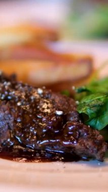 Orta pişmiş biftek barbekü sosu, taze salata ve cömert bir patates kızartması ile tamamlanır. Yüksek kalite 4k görüntü