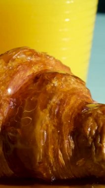 Tahtada kruvasan, arka planda portakal suyu servis ediliyor. Yüksek kalite 4k görüntü