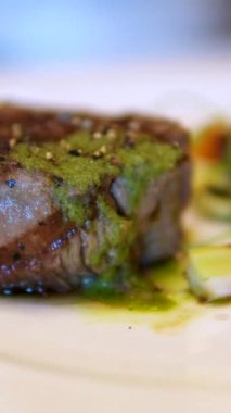 Lezzetli fileto biftek, hamursuz soslu, mikro yeşil salata ve süslü bir restoranda vişneli domates, öğle yemeği, 4K shot. Yüksek kalite 4k görüntü