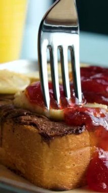 Fındık reçelli muzlu sandviç. Çatalla kesilmiş lezzetli bir öğle yemeği ekmeği kırmızı manikürlü bir kadın eli