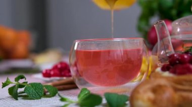 Sütteki chia tohumlarına bal ve hindistan cevizi tozu ekleniyor. Ahududu çayına bal ekle