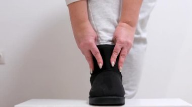 Siyah resmi ayakkabılar giyen ve yürüyen bir kadının statik sinema videosu. siyah ugg çizmeleri