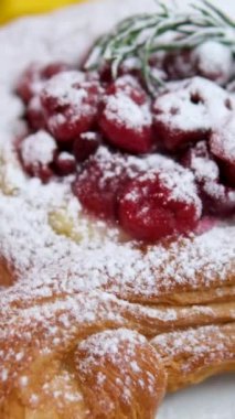 Süslü ahududu tartının üst manzarası kremalı, taze nane yapraklı ve pudra şekerli. Tatlı ve pasta sunumları için ideal. Yüksek kalite 4k görüntü