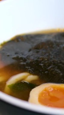 Lezzetli bir kase ramen, içinde mısır, yosun, erişte, yumurta ve et var. Yakın çekim zengin, besleyici çorbayı yakalar, yemek tutkunları için mükemmel bir aşçılık ilham kaynağıdır. Yüksek kalite