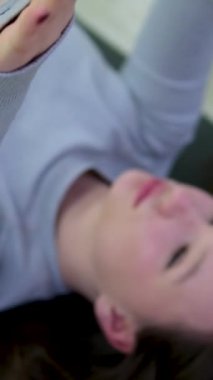 Lotus pozunda oturan sportif kadın, kollarını kaldırıyor ve yan yana uzanıyor, yerde saksı bitkileri, arka planda pencereler. Esnek kadın stüdyoda yoga yapıyor. Zindelik kavramı