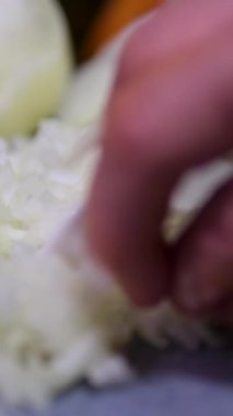 Şef, kırmızı soğanı kesme tahtasının üzerinde bıçakla doğruyor, profesyonel mutfakta kırmızı soğan keserken makroyu kapatıyor. Yüksek kalite 4k görüntü