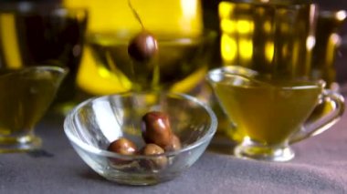 Süper yavaş çekimde taze olgun zeytin makrosu biyo-organik altın sıvı ekstra saf zeytinyağına dökülüyor ve olgun zeytinlere damlıyor. Yüksek kalite 4k görüntü